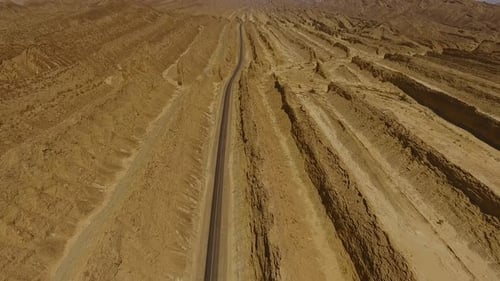 Aerial view of desert terrain with road and hills, Pakistan.