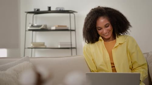 Smiling Woman Working on Laptop Indoors at Home
