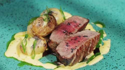 Juicy Medium Beef Meat Rib Eye Steak Slices with Baked Potato in Expensive Modern Fusion Restaurant