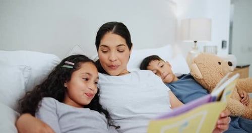 Mother Reading Bedtime Story to Children in Bed