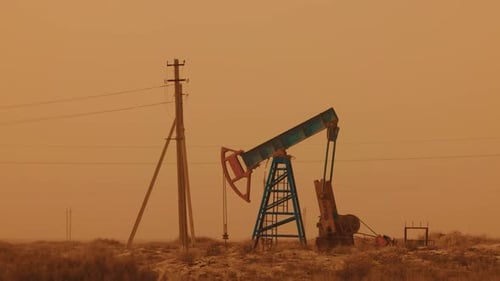 Pumping Petroleum Rig in Desert at Sunset Oil Industry Pump Jack Extracting Crude Oil From a Oil