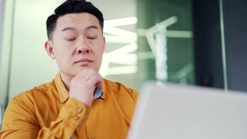 Close up of a thoughtful businessman thinking about a solution to a problem while sitting