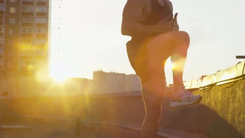 Man Exercising Outdoors on Rooftop at Sunrise