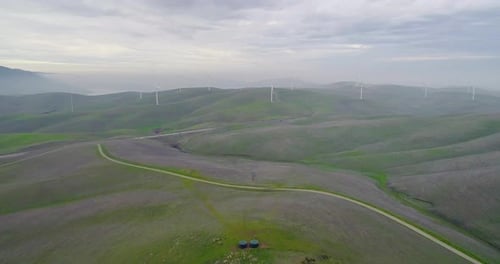 Reverse Dolly of Distant Wind Turbines Engulfed in Smokey Mountain Mist