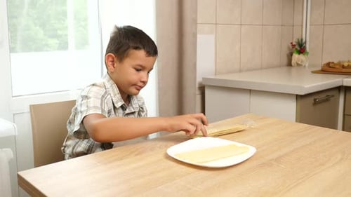 97. The boy puts potato chips on a plate.