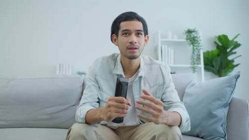 Young Man Watching TV on the Sofa