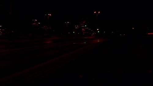 Zusammenfassung des Verkehrs: Ampeln, sich bewegende Verkehrsampeln, Zeitrafferverkehr in der Stadt, rote und blaue Lichtlinien in