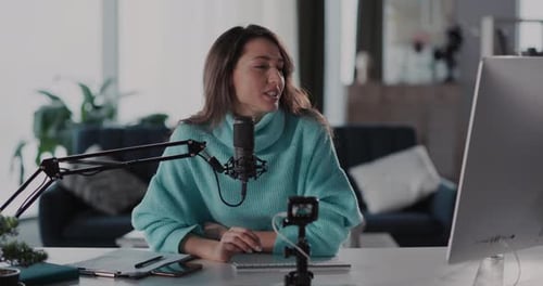 A Young Woman Engaging in Live Streaming From Her Cozy and Comfortable Home Office Space