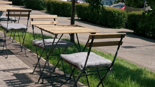 Vertical Video Close Up in a Restaurant on the Street on Plank Table a Blue Plate with a Warm Salad