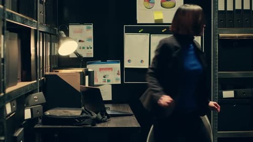 Focused Woman Working in a Dark Office