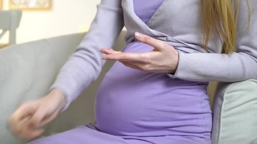 Pregnant Diabetic Young Woman Measuring Blood Glucose Level with a Glucometer