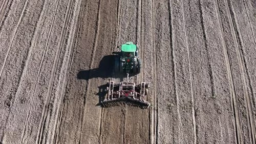 Tractor Harrows Field from Aerial Perspective