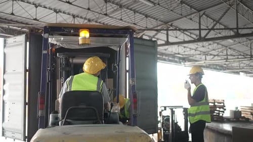 Blue collar workers are working at warehouse.