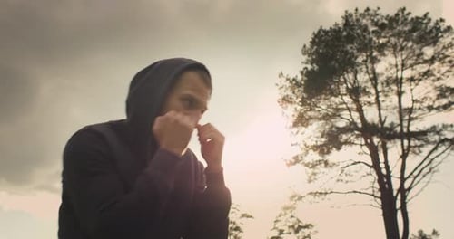 Hooded Man Shadow Boxing at Golden Hour
