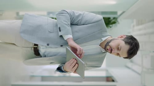 Man Uses Tablet in Bright Modern Office