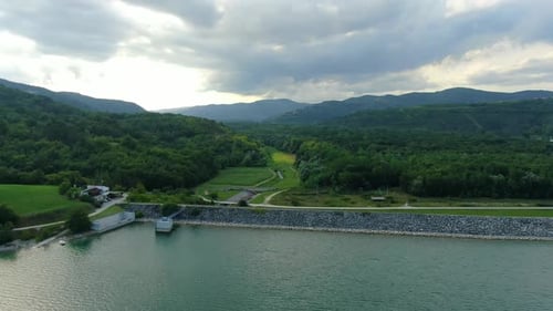 Lake Butoniga freshwater reservoir in Croatia approaching dam wall on an overcast day, Aerial drone