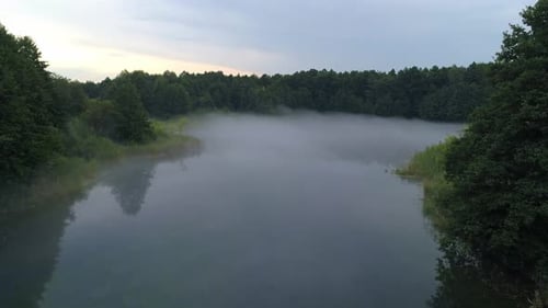 Early Morning Mist Floating Over Calm Water Lake Aerial View Flying Slowly and Low Over a Lake in