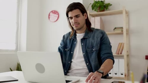 Young Creative Professional Working on Laptop in Modern Office