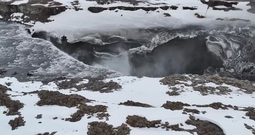 This epic shot of Dettifoss Waterfall in Iceland displaying a mesmerizing black mountain coated in a