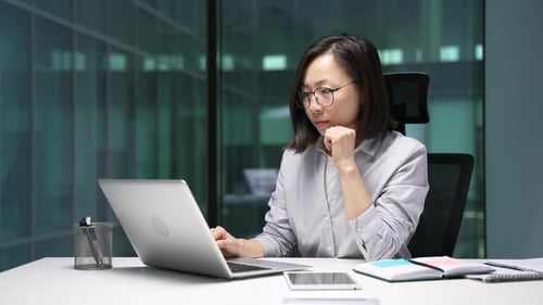 Woman Working on Laptop in Modern Office