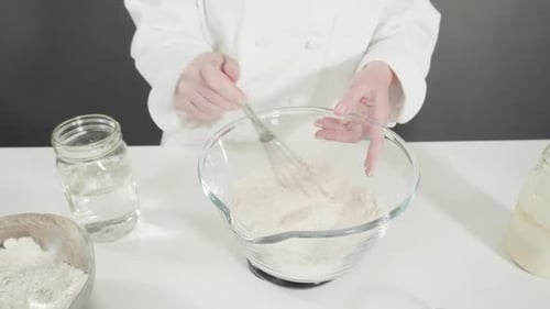 Time Lapse Measuring Ingredients Into a Glass Bowl to Bake Cinnamon Rolls