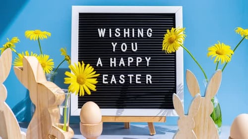 Happy Easter message on board with eggs and flowers