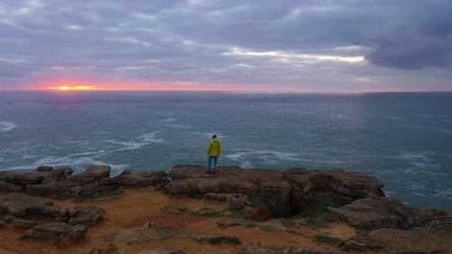 Lonely Man is Standing on the Edge of Cliff Peniche Portugal Aerial View