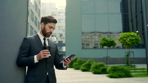 Professional Man Leans Against Building with Cellphone