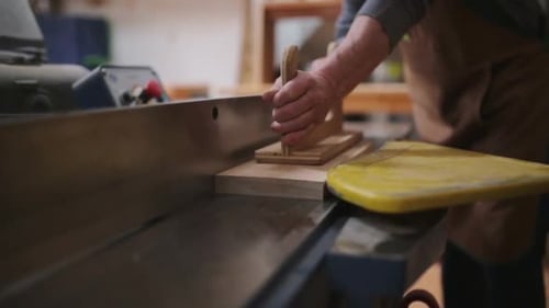 Senior carpenter skillfully cuts wood with table saw in calgary alberta workshop