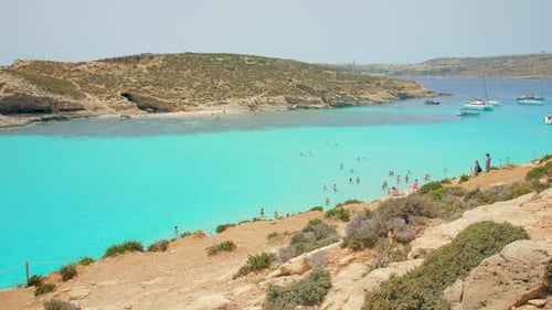 Blue Lagoon, Comino, Malta – Aerial shot of a busy blue lagoon filled with ships. Blue Lagoon bay in