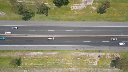Top-Down 90 Lateral Drone Aerial Motion Over Highway With Light Traffic and Green Rural Fields in