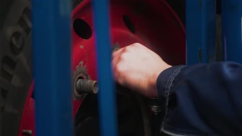 Eine Radschraube wird von Hand angeschraubt