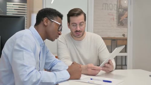 Business People Discussing Project on Digital Tablet in Office