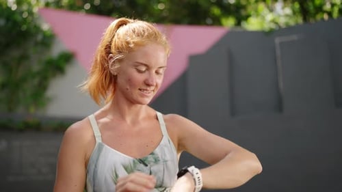 Redhead Pro Athlete Checks Smart Watch at Tropical Gym Woman Monitors Health Stats Performance