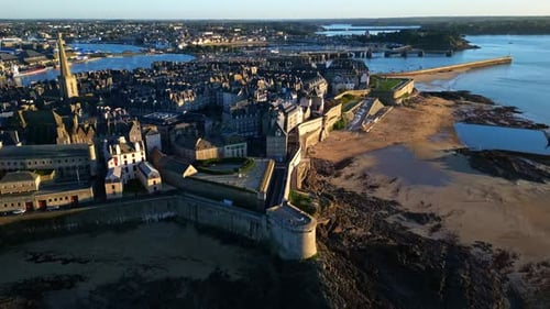 Receding drone movement from the Intra Muros district at sunset, Saint-Malo, France.