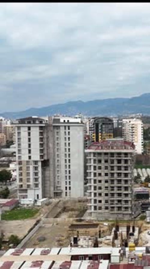 Vídeo vertical: elevación urbana: perspectiva aérea de obras de construcción y apartamentos de lujo