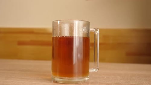 93. Two spoons of sugar are added to a glass of hot aromatic tea.
