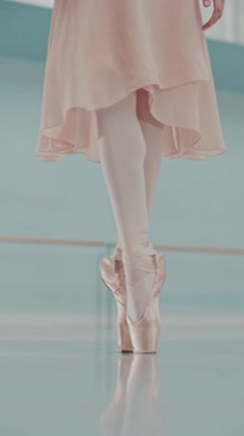 Ballerina in pointe shoes dancing on the floor. Dancer's legs close up. Dance ballet pas training.