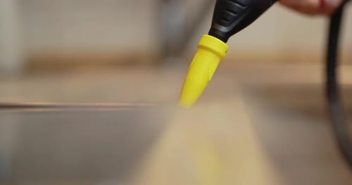 Steam Cleaner Nozzle Cleaning a Reflective Surface