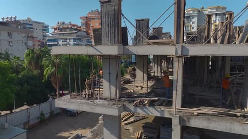 Aerial View Construction of a HighRise Building With Cranes and Workers