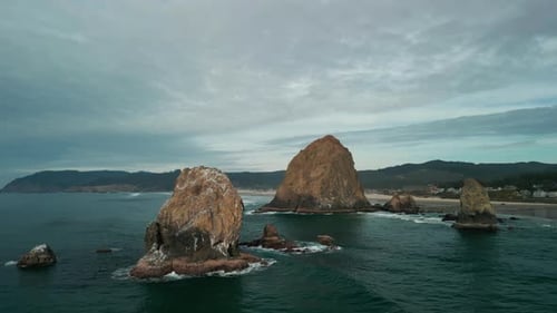 Wide Aerial Shot of Haystack Rock Beach in Coastal Town Cannon Beach Oregon