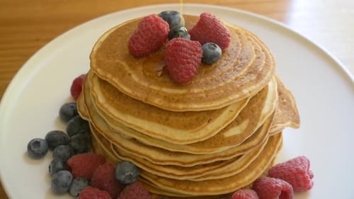 Pancakes Stacked High, Poured with Syrup and Berries