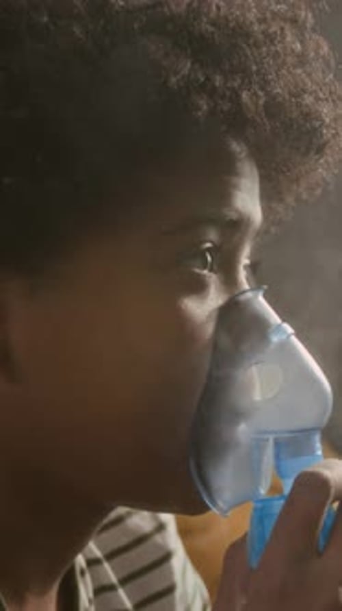 Garçon utilisant un masque nébuliseur pour inhaler un médicament pour soulager l'asthme