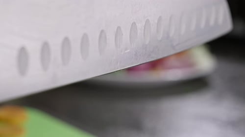 Knife Chopping Carrots on Green Cutting Board