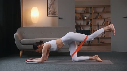 Woman Doing Donkey Kick Exercise with Resistance Band