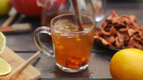 Closeup Stirring Berries in Green Tea with Cinnamon Stick Outdoors on Autumn Day