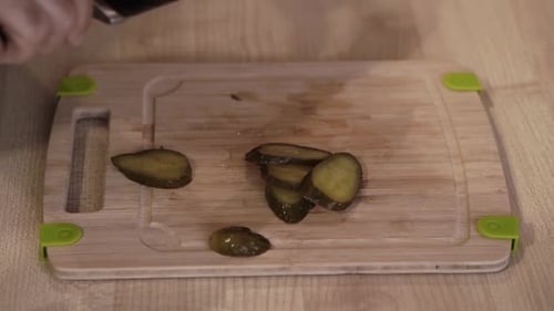 Man makes pizza at home and slicing ingredients