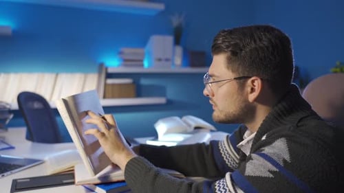 Selbstbewusster junger Mann, der ein Buch für die Erstellung von Forschungsberichten liest.