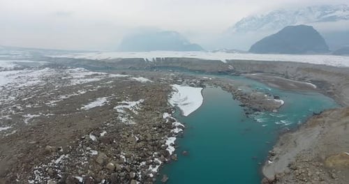Aerial view of snowy landscape with river, valley, mountains, Pakistan.