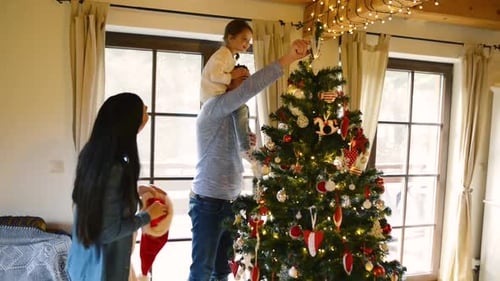 Family Decorating Christmas Tree in Cozy Home